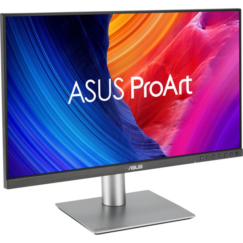 A widescreen ASUS ProArt computer monitor with a thin bezel, showing a colorful abstract background on the display, mounted on a silver rectangular stand.