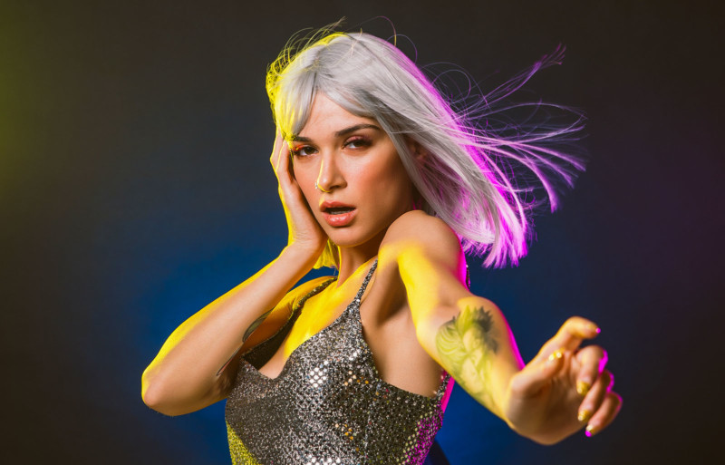 Young woman with grey hair dancing and celebrate. Colored gel portraits
