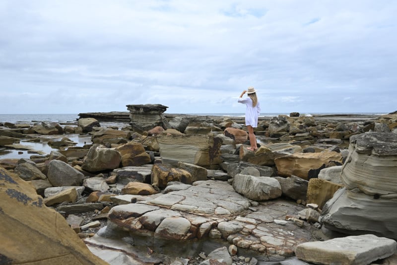 Environmental portrait of a woman at a rocky beach