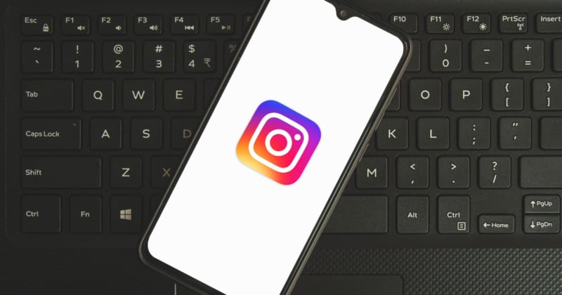 Instagram logo on a smartphone sitting on a keyboard.