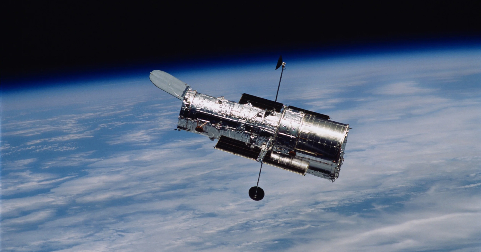 The Hubble Space Telescope as seen from space with Earth in the background