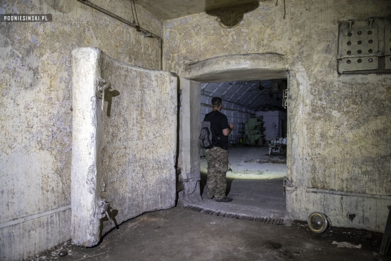 An urban explorer standing in the doorway of an underground ammo factory