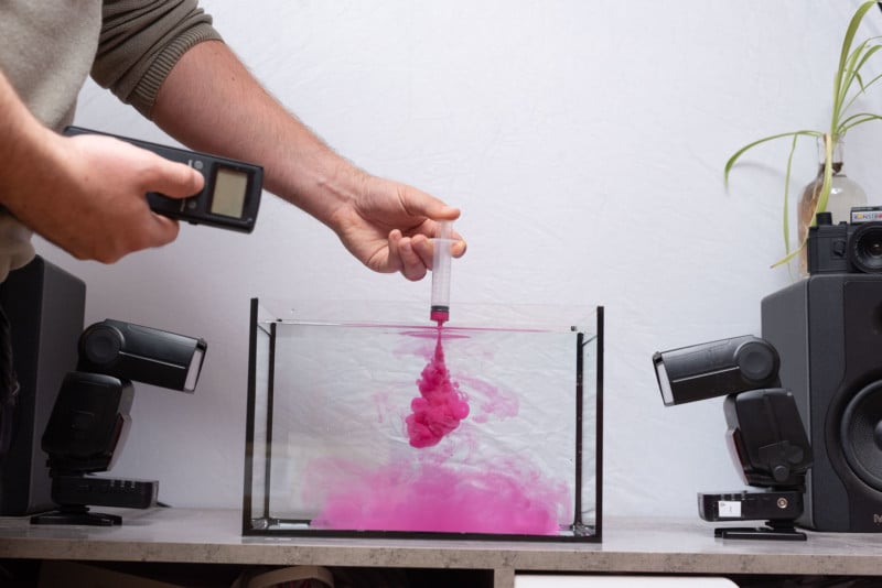 Person photographing and pouring paint simultaneously