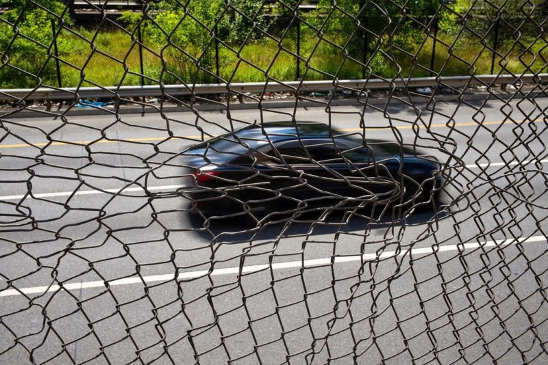 A car driving behind a wire fence