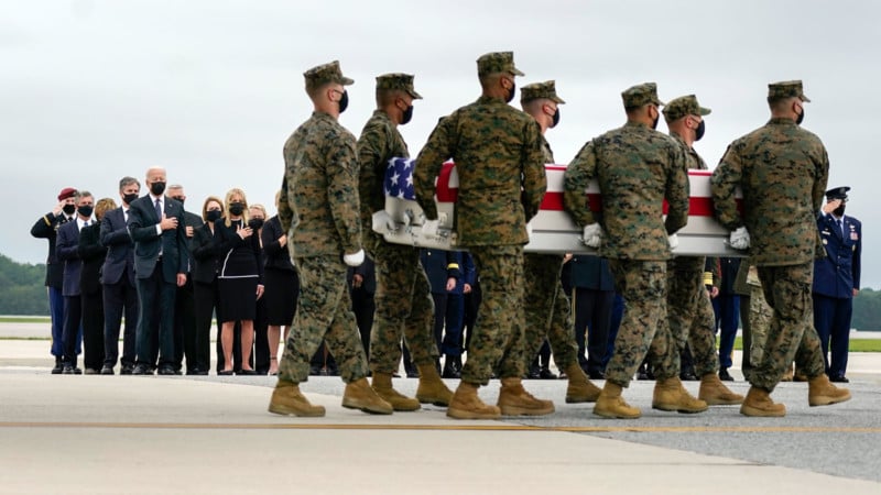 Marines carry a coffin draped in an American flag
