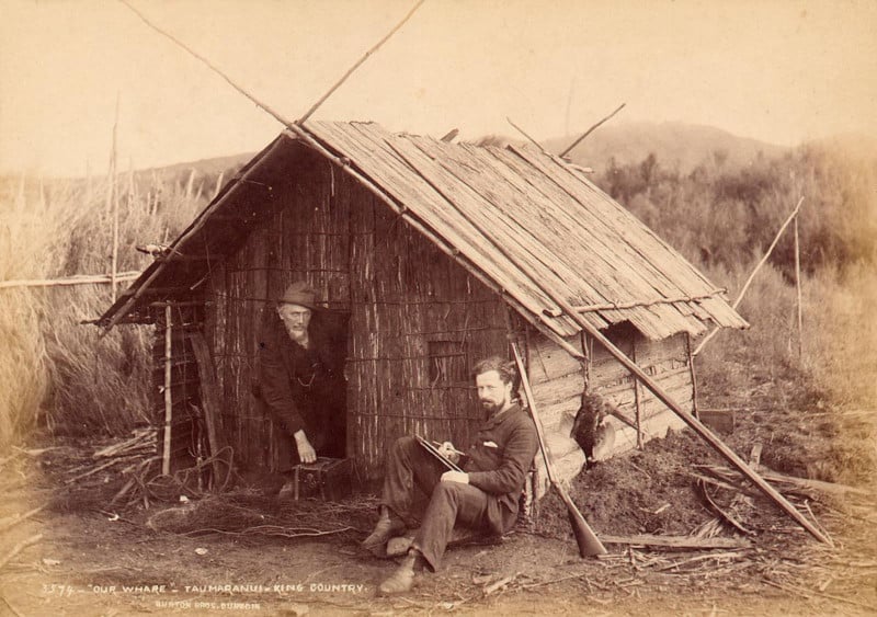 A vintage photo of colonial explorers Burton and Payton outside a whare