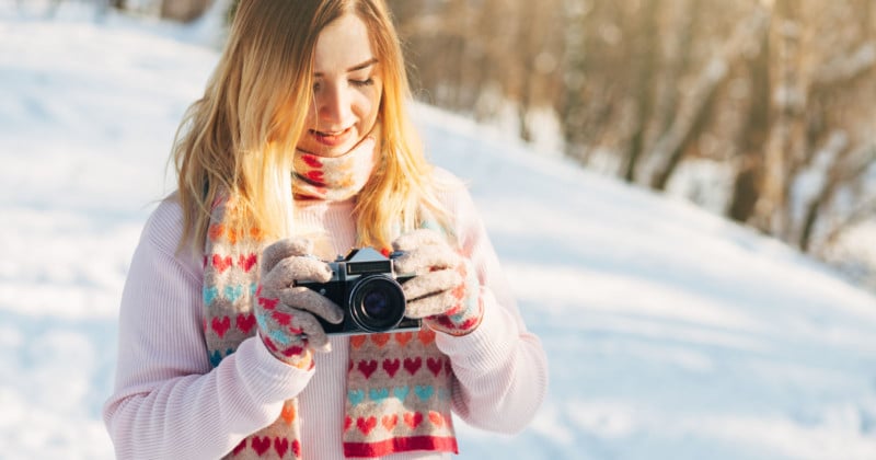 A woman looking at a camera in a snowy outdoor scene