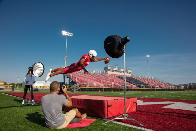 A photographer does a photo shoot with a diving football player