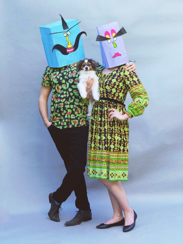Two people wearing decorated paper bags on their heads