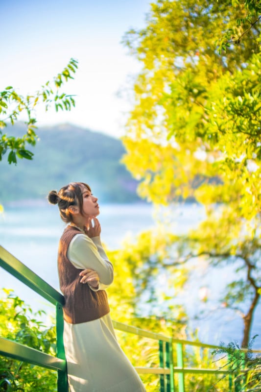 A portrait of a woman looking up at a tree