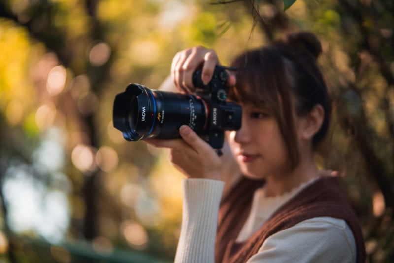 A woman shooting a photo with the Venus Optics Laowa Argus 45mm f/0.95 FF lens