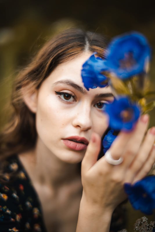 A portrait of a woman posing with a flower