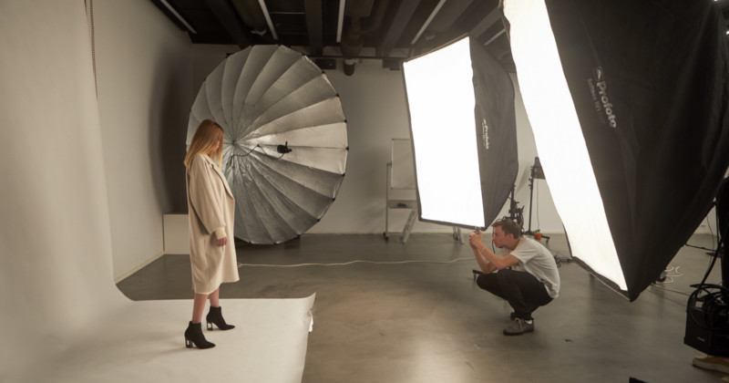 A man shooting a portrait of a woman with giant softboxes