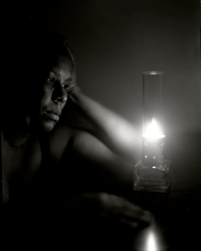 A photo of a woman looking at a candle