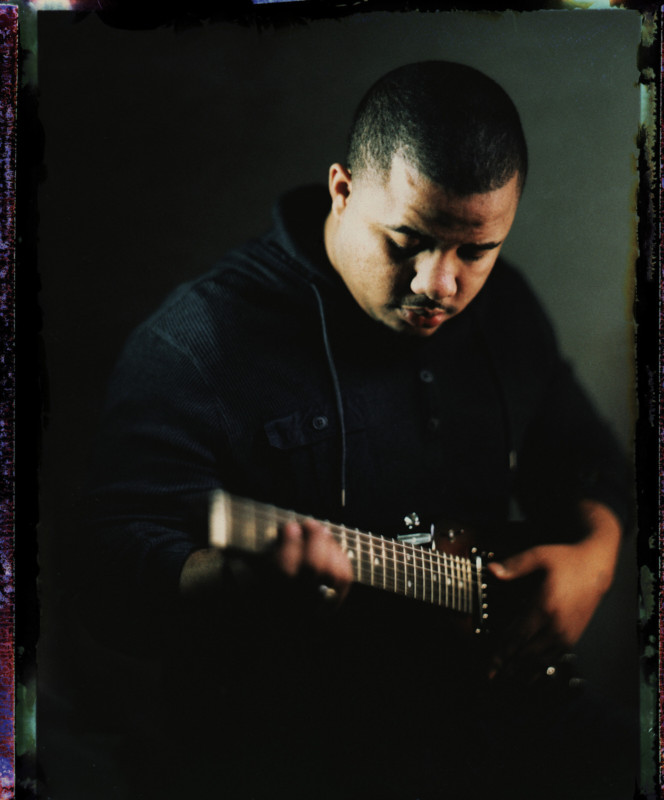 A photo of a man playing a guitar