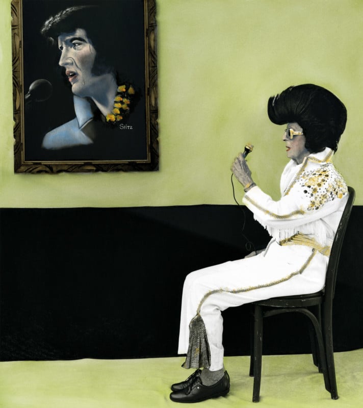 A woman dressed like Elvis sitting in a green room
