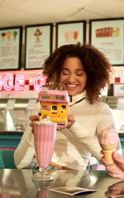 Woman holding malibu barbie instant camera