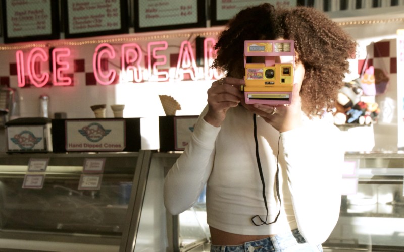 Woman holding malibu barbie instant camera