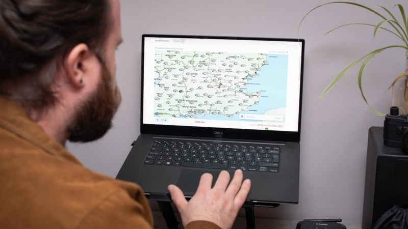 Person checking weather forecast on laptop