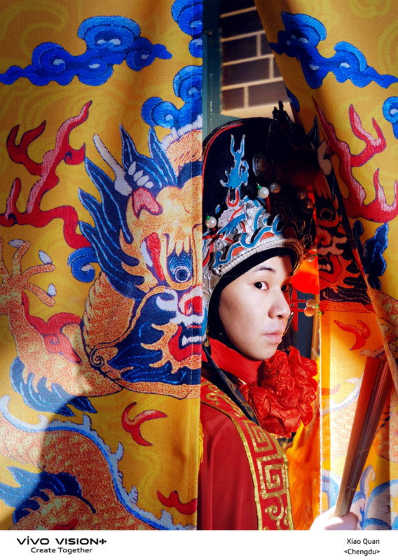 A Chinese man looking through a gap in cloth with a dragon design