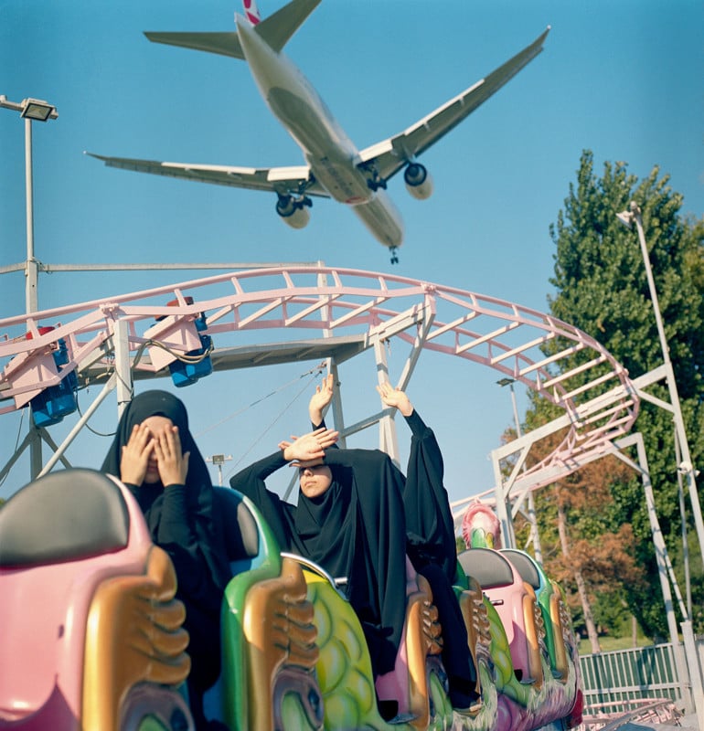 A plane flies over students at an amusement park, Istanbul, 2018. © Sabiha Çimen/Magnum