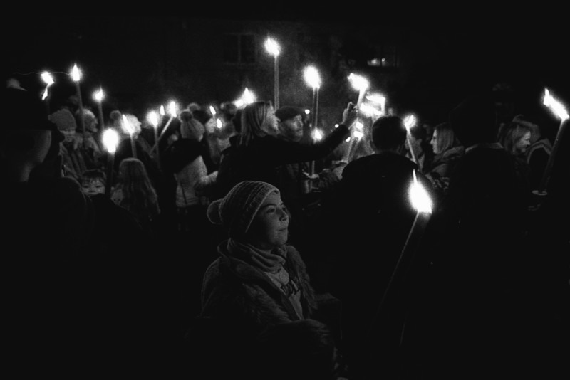 A crowd holding torches in a street