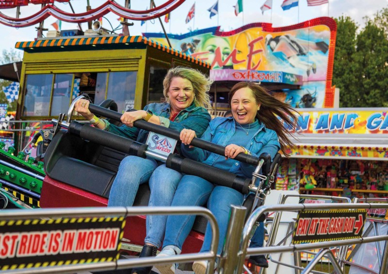 Two older ladies riding a ride at a fair