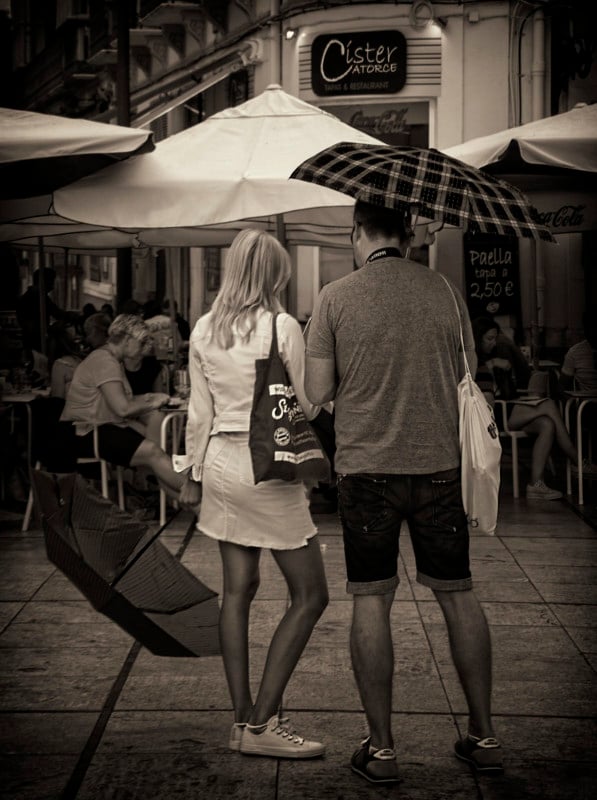 A man and woman under umbrellas