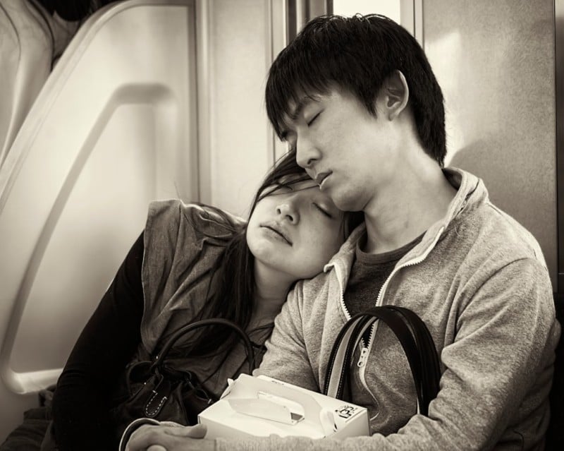 A couple sleeping on a subway car