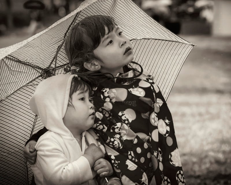 Two children under an umbrella