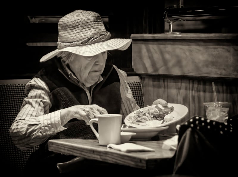 An old lady holding a plate of food