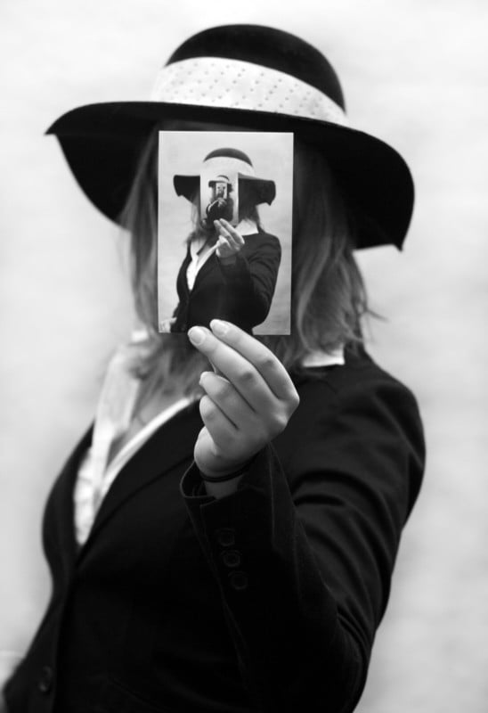 A woman holding a photo of her holding a photo