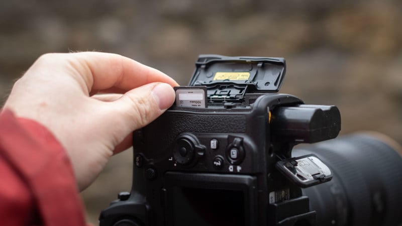 Person putting memory card and battery in camera