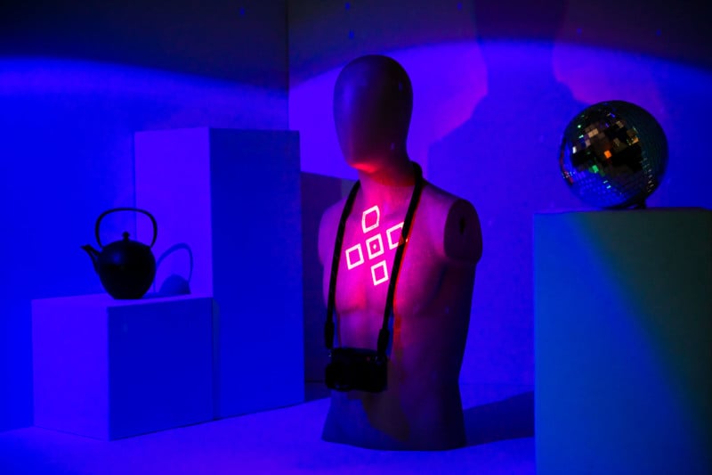 A mannequin lit up with a pink projector