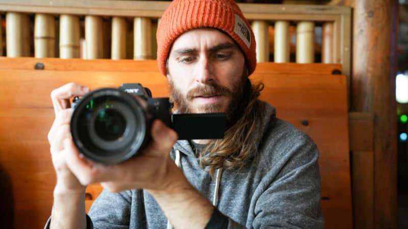 A photographer holding a Sony mirrorless camera