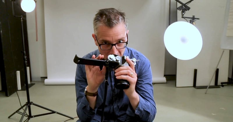 A photographer smelling a 35mm film camera