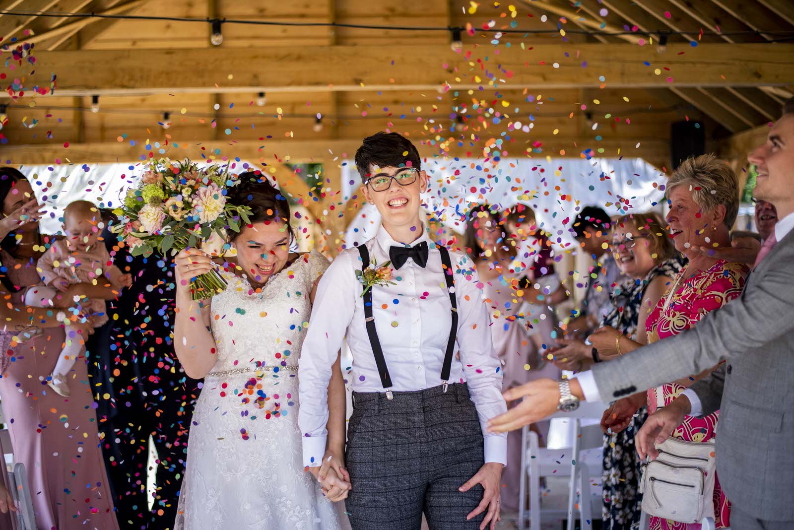 A wedding couple walking through confetti
