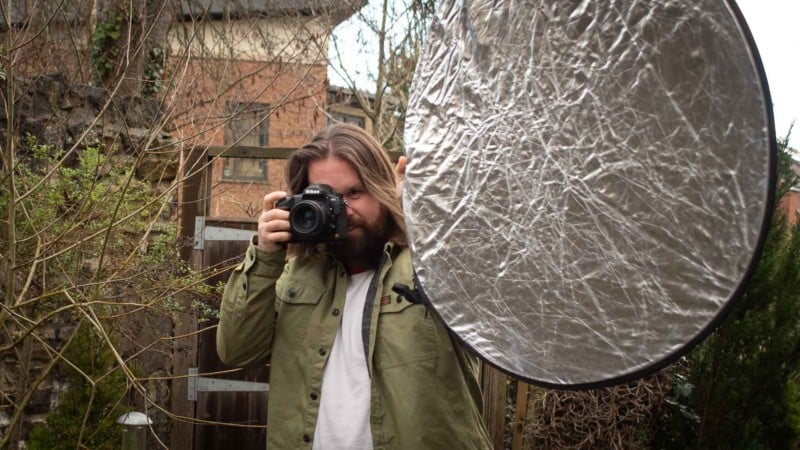 A photographer with reflector in hand