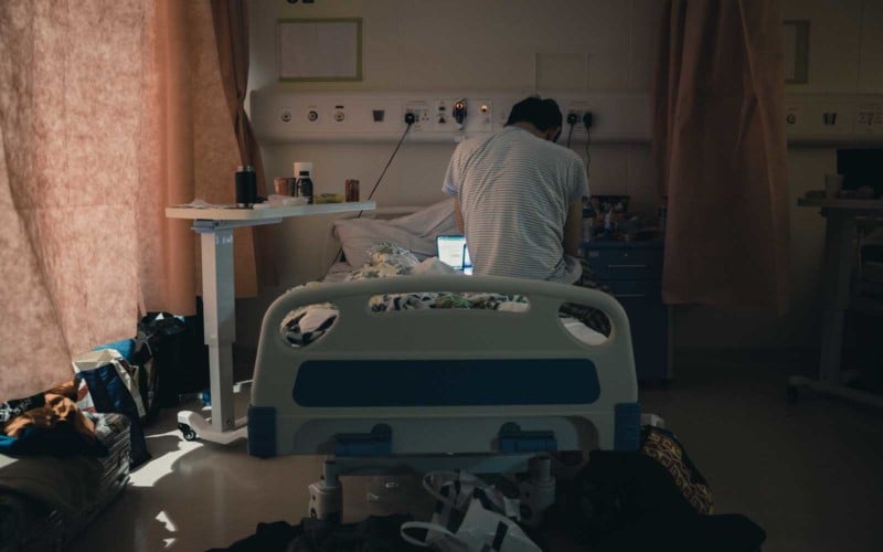 A patient uses his laptop in Hong Kong's COVID hospital isolation