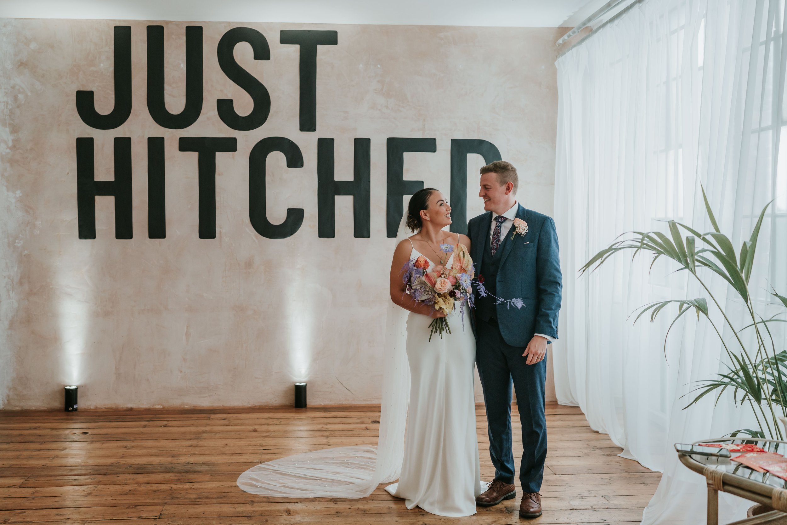 A married couple in front of a 'Just Hitched' sign