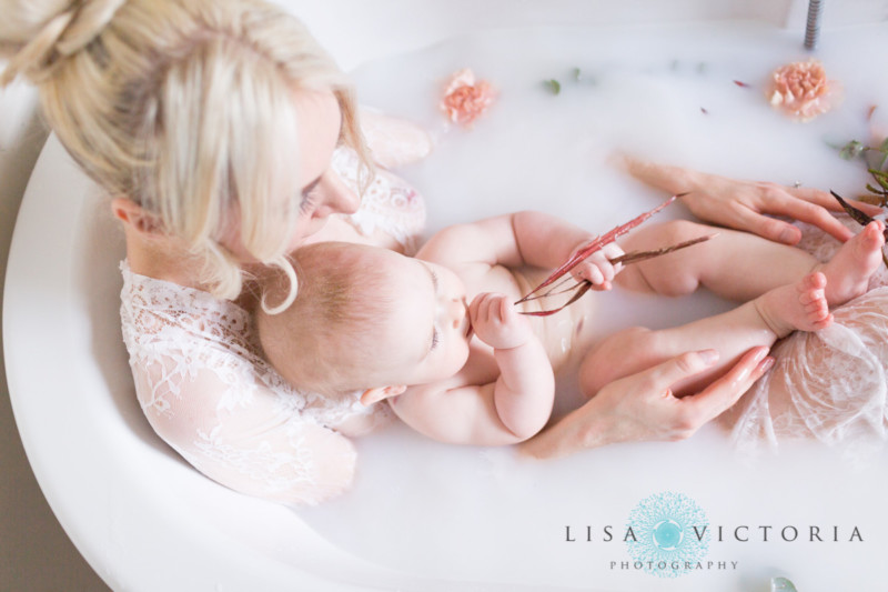 A milk bath photo with a mother and her baby