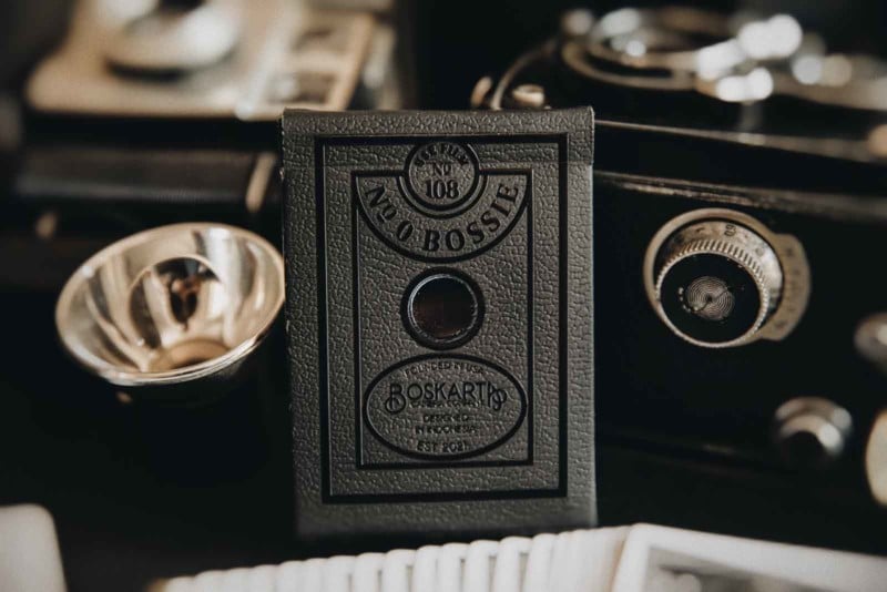 Kotak kartu dek Buscarta dirancang agar terlihat seperti kamera kue tua.
