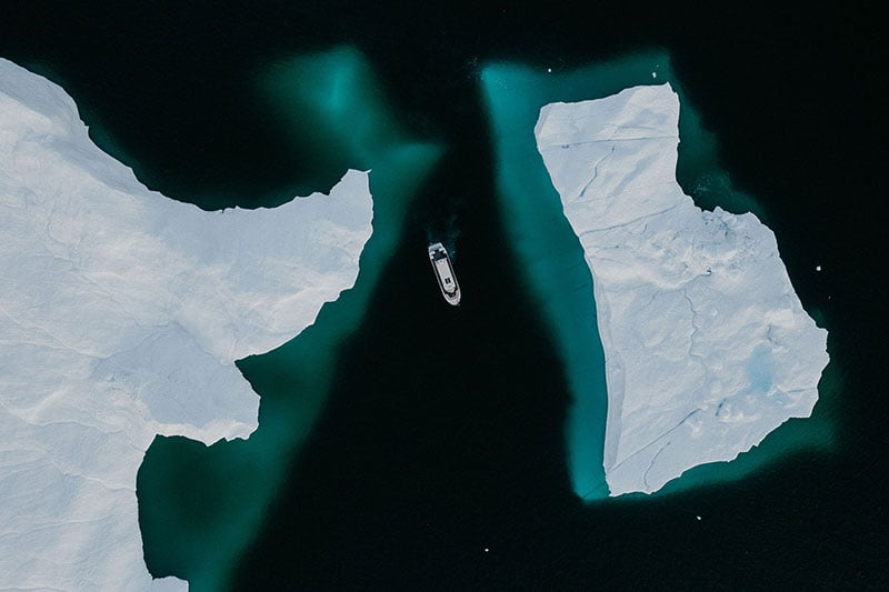 Aerial drone shot of the dark blue and teal ocean in Greenland