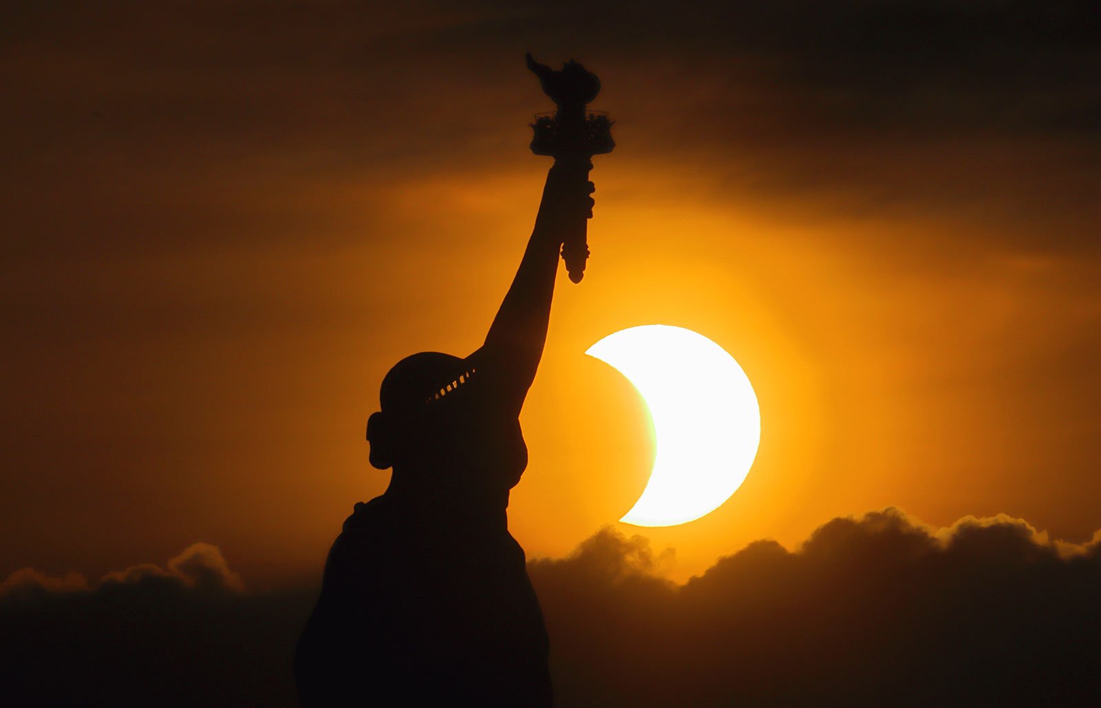 The Statue of Liberty and a solar eclipse in the background
