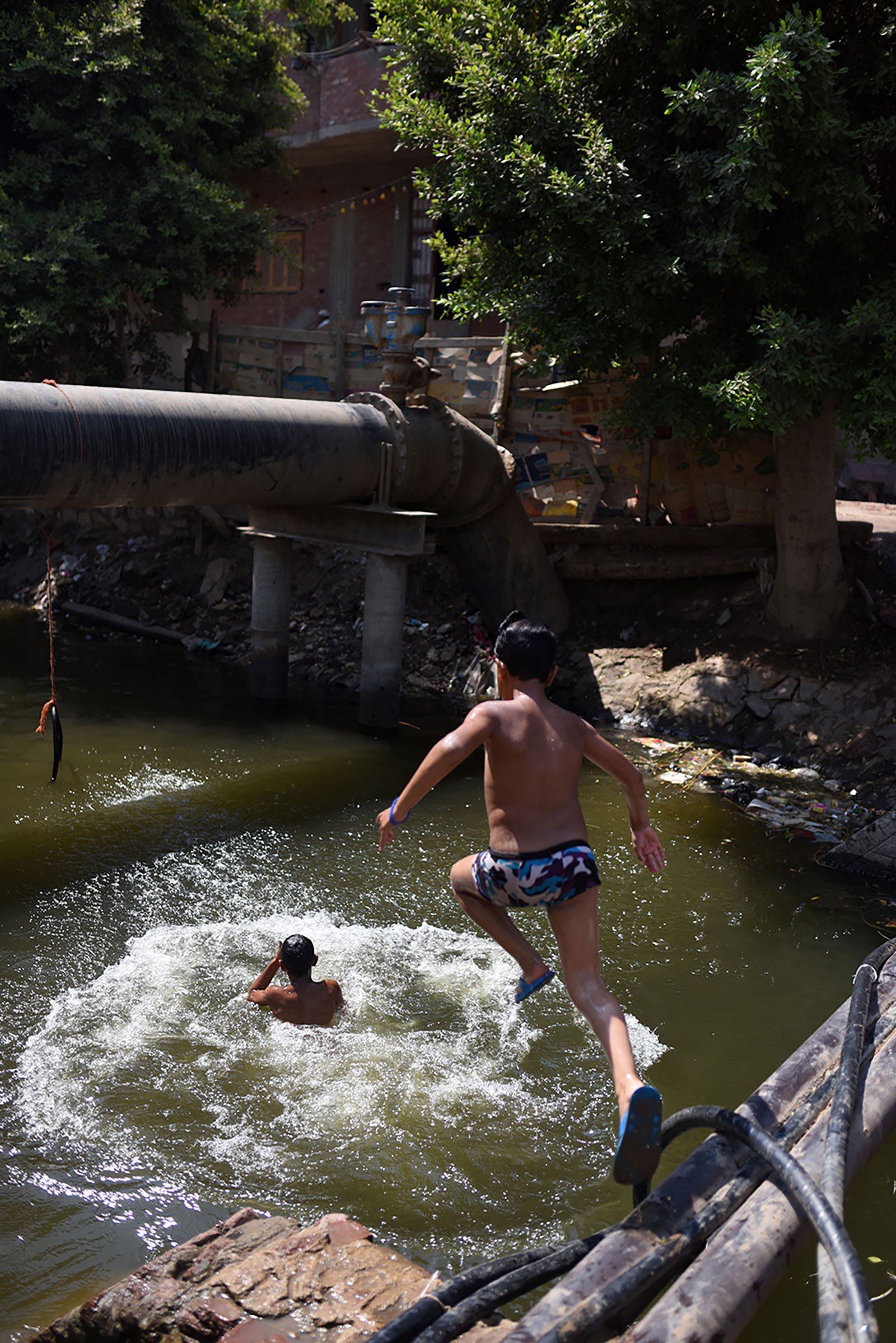 Young people jumping into a swimming area