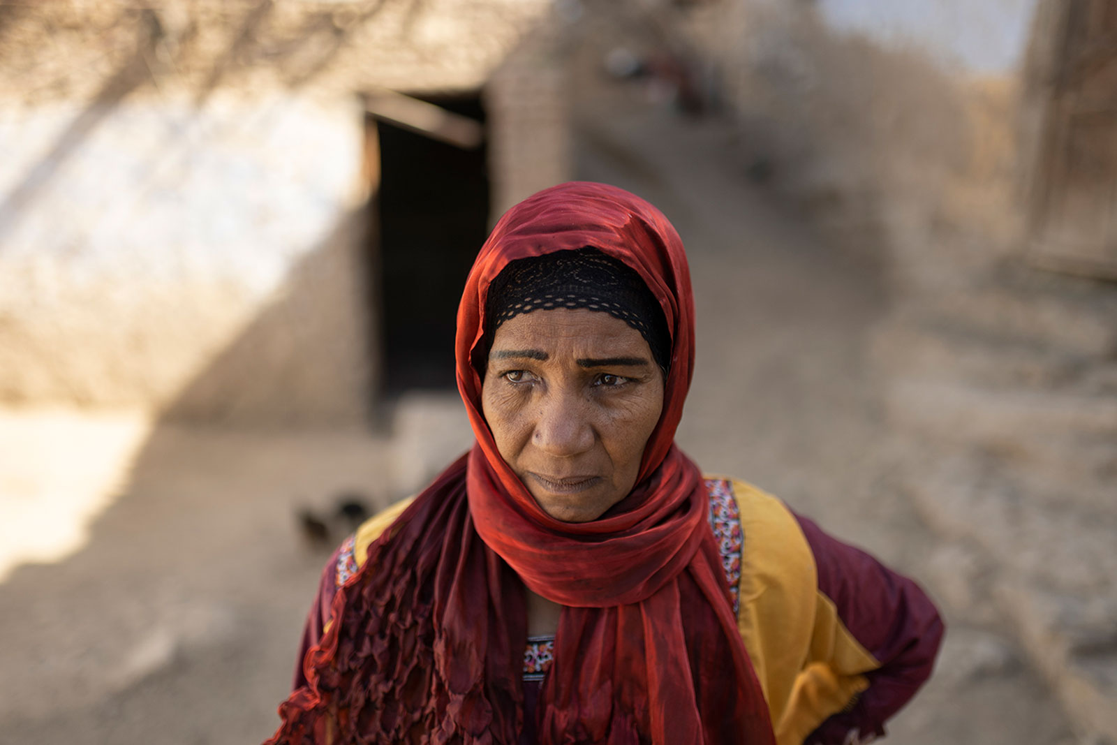 woman in red hijab and housing behind her