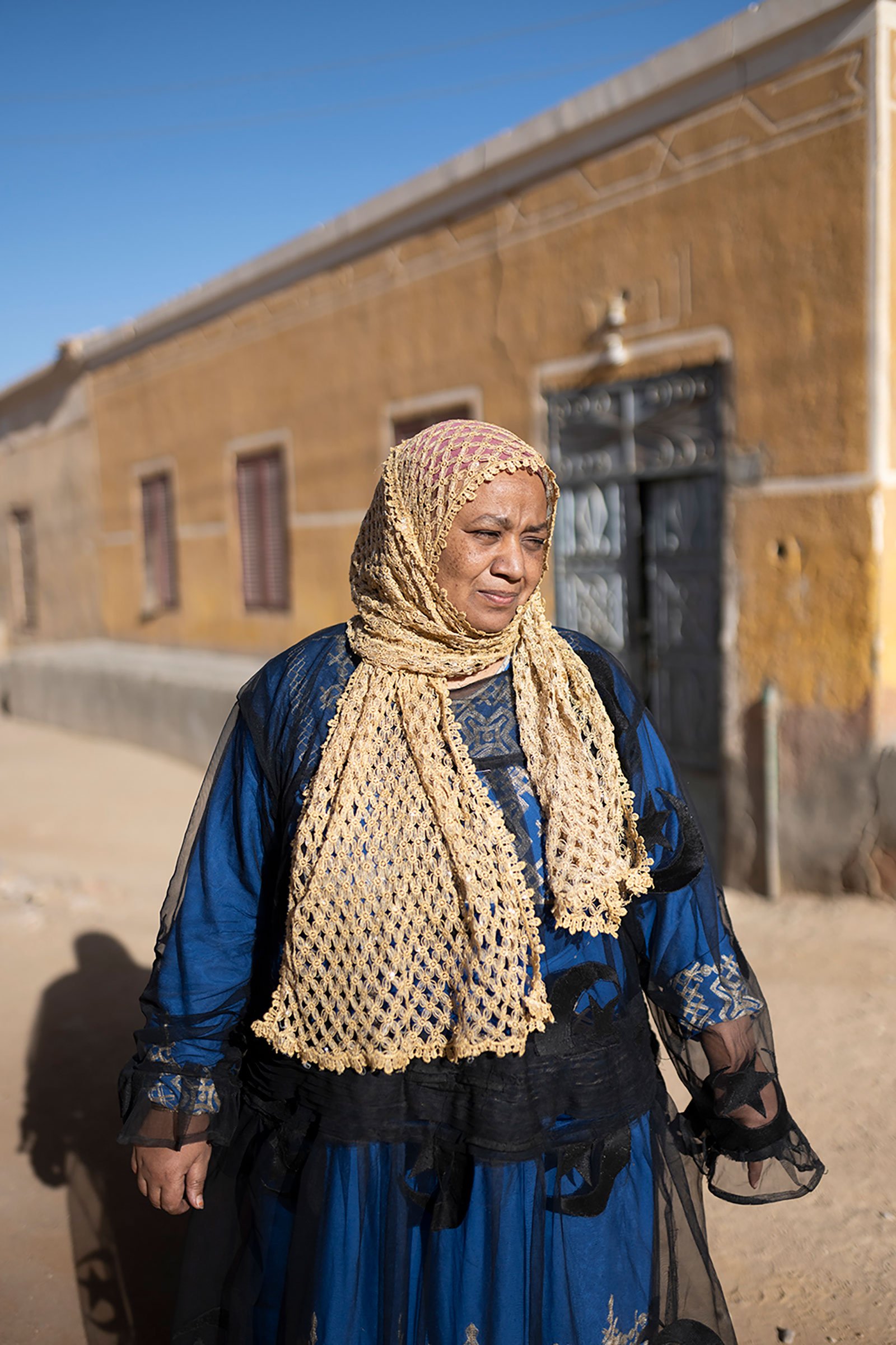 woman in lattice hijab and housing behind her
