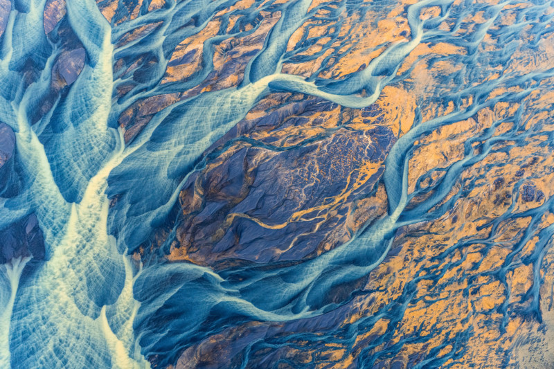Ljust färgat sediment målar det isländska landskapet när det strömmar mot havet.  Glaciärfloden, Þjórsá, är den längsta floden på Island.