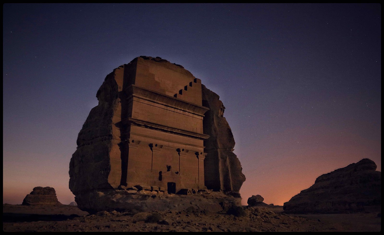 Ruins in Saudi Arabia with dark blue and pink sunset in the background