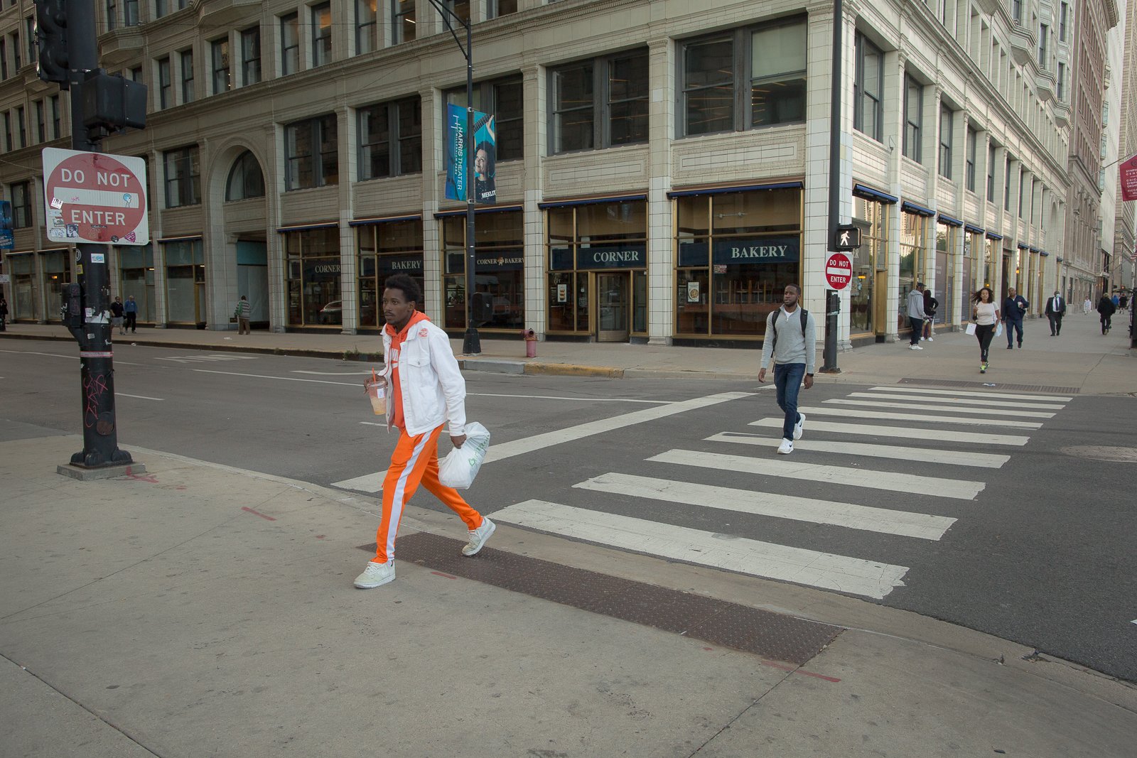 People crossing a cross walk in a city, looking at camera